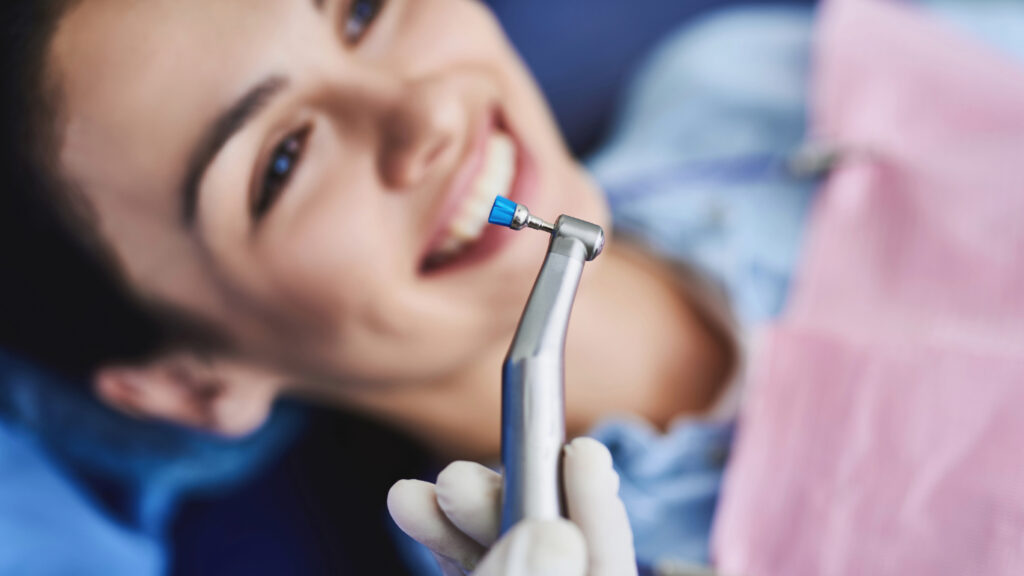 Lächelnde Patientin erhält eine professionelle Zahnreinigung beim Zahnarzt