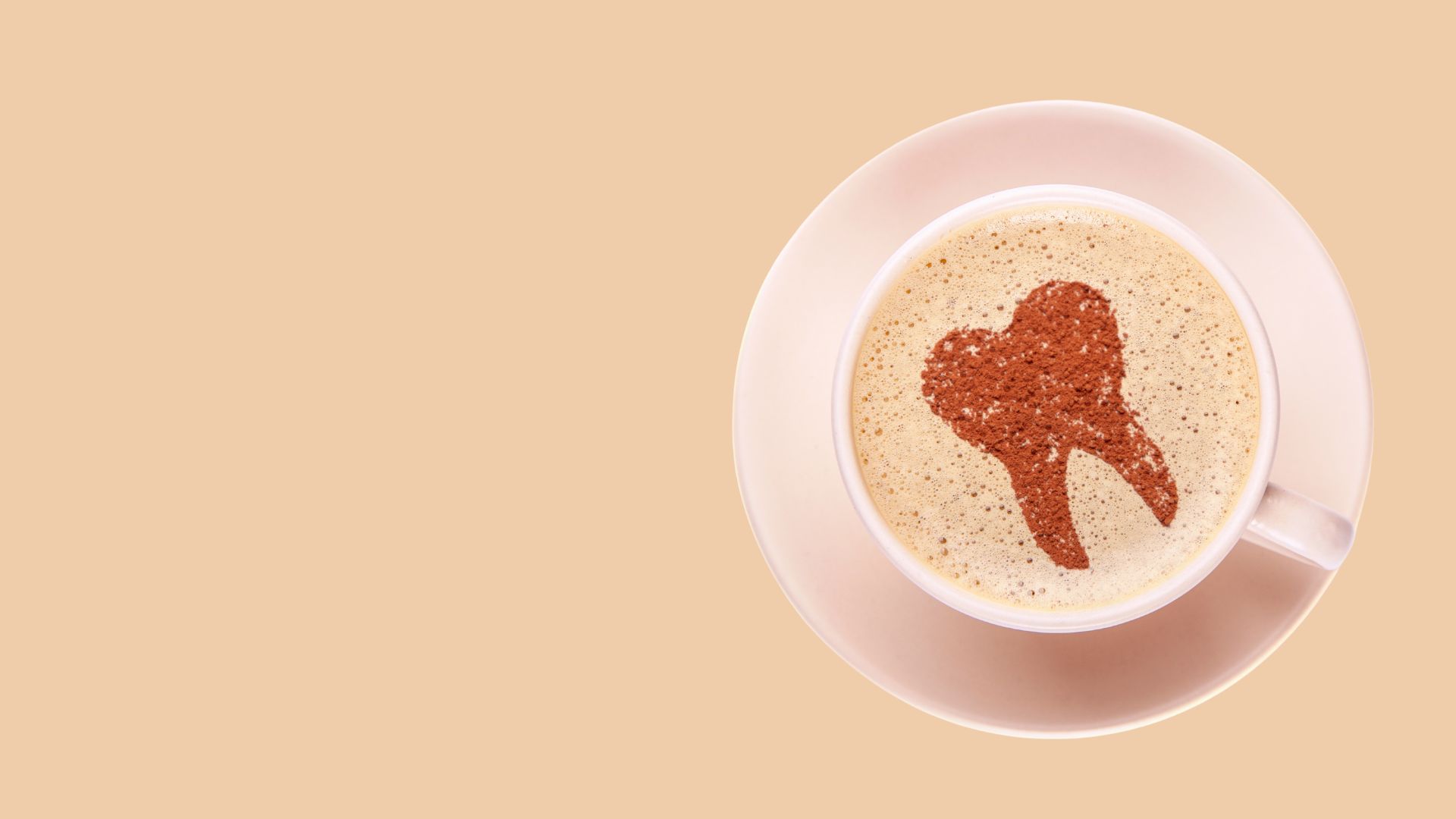 Tasse Kaffee mit Zahnmotiv auf der Schaumkrone